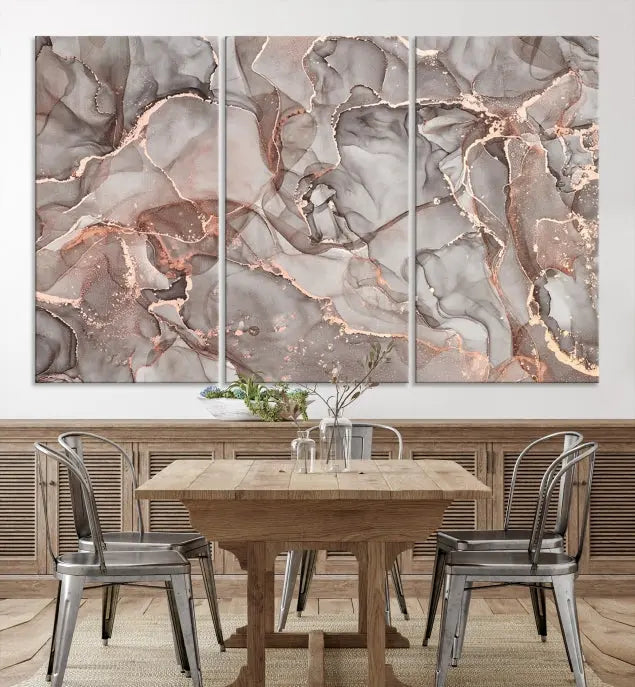 The Rose Gold Marble Fluid Effect Wall Art Abstract Canvas Wall Art Print is an exquisite three-panel creation crafted on museum-quality canvas. It features swirling marbled patterns in shades of gray, copper, and beige. Complete with a UV-protective coating, this ready-to-hang artwork promises to be a timeless addition to any space.