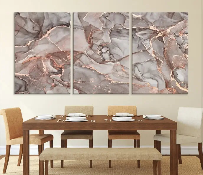 The Rose Gold Marble Fluid Effect Wall Art Abstract Canvas Wall Art Print is an exquisite three-panel creation crafted on museum-quality canvas. It features swirling marbled patterns in shades of gray, copper, and beige. Complete with a UV-protective coating, this ready-to-hang artwork promises to be a timeless addition to any space.