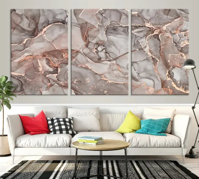 The Rose Gold Marble Fluid Effect Wall Art Abstract Canvas Wall Art Print is an exquisite three-panel creation crafted on museum-quality canvas. It features swirling marbled patterns in shades of gray, copper, and beige. Complete with a UV-protective coating, this ready-to-hang artwork promises to be a timeless addition to any space.