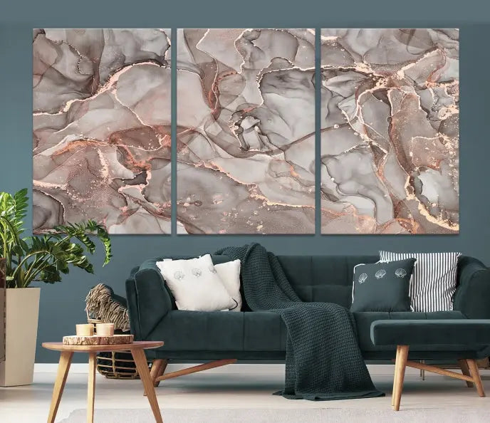 The Rose Gold Marble Fluid Effect Wall Art Abstract Canvas Wall Art Print is an exquisite three-panel creation crafted on museum-quality canvas. It features swirling marbled patterns in shades of gray, copper, and beige. Complete with a UV-protective coating, this ready-to-hang artwork promises to be a timeless addition to any space.