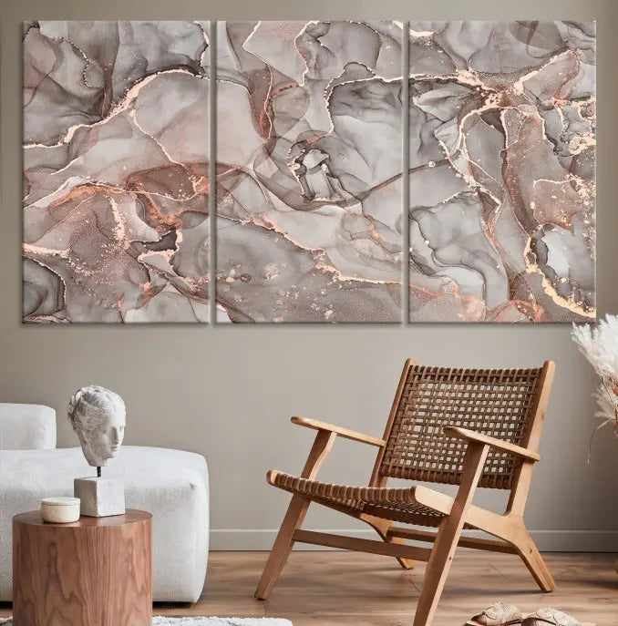 The Rose Gold Marble Fluid Effect Wall Art Abstract Canvas Wall Art Print is an exquisite three-panel creation crafted on museum-quality canvas. It features swirling marbled patterns in shades of gray, copper, and beige. Complete with a UV-protective coating, this ready-to-hang artwork promises to be a timeless addition to any space.