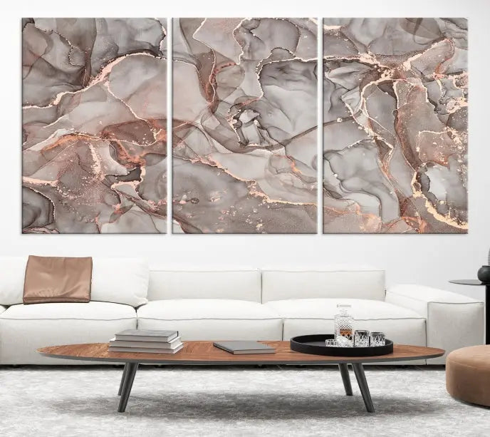 The Rose Gold Marble Fluid Effect Wall Art Abstract Canvas Wall Art Print is an exquisite three-panel creation crafted on museum-quality canvas. It features swirling marbled patterns in shades of gray, copper, and beige. Complete with a UV-protective coating, this ready-to-hang artwork promises to be a timeless addition to any space.