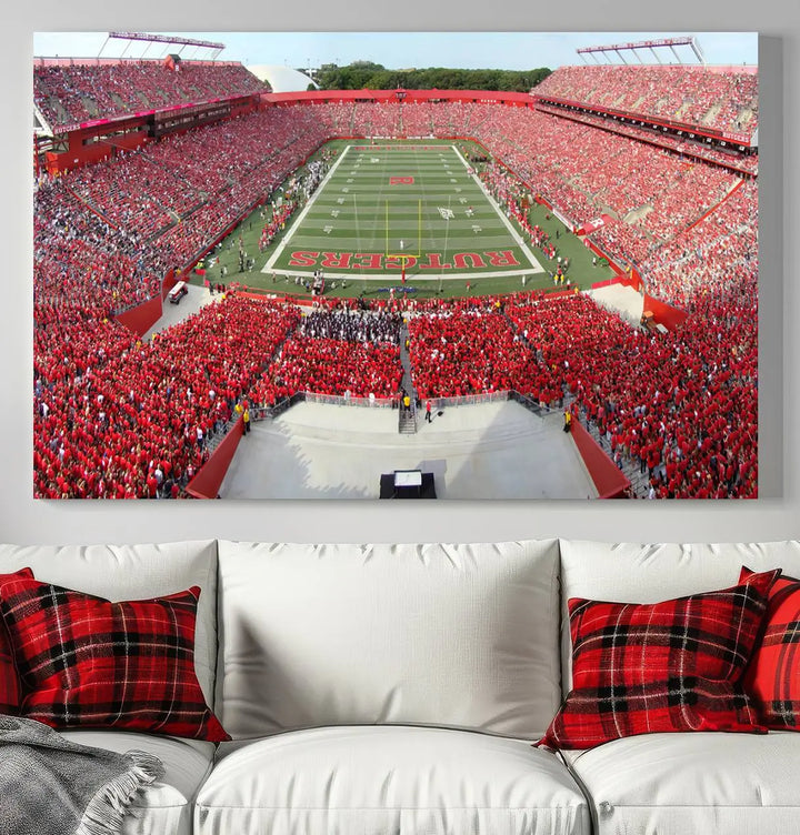 The room features a large wall art piece titled "Rutgers Scarlet Knights Football Team Print - Piscataway SHI Stadium Wall Art Canvas Print." This artwork showcases a vibrant, packed football stadium and boasts a gallery-quality finish on premium canvas, adding an elegant touch to the lively scene.