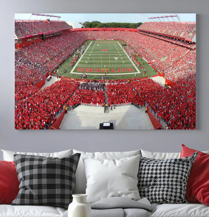 The room features a large wall art piece titled "Rutgers Scarlet Knights Football Team Print - Piscataway SHI Stadium Wall Art Canvas Print." This artwork showcases a vibrant, packed football stadium and boasts a gallery-quality finish on premium canvas, adding an elegant touch to the lively scene.