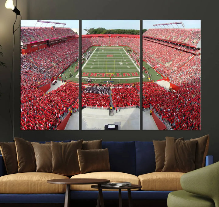 The room features a large wall art piece titled "Rutgers Scarlet Knights Football Team Print - Piscataway SHI Stadium Wall Art Canvas Print." This artwork showcases a vibrant, packed football stadium and boasts a gallery-quality finish on premium canvas, adding an elegant touch to the lively scene.