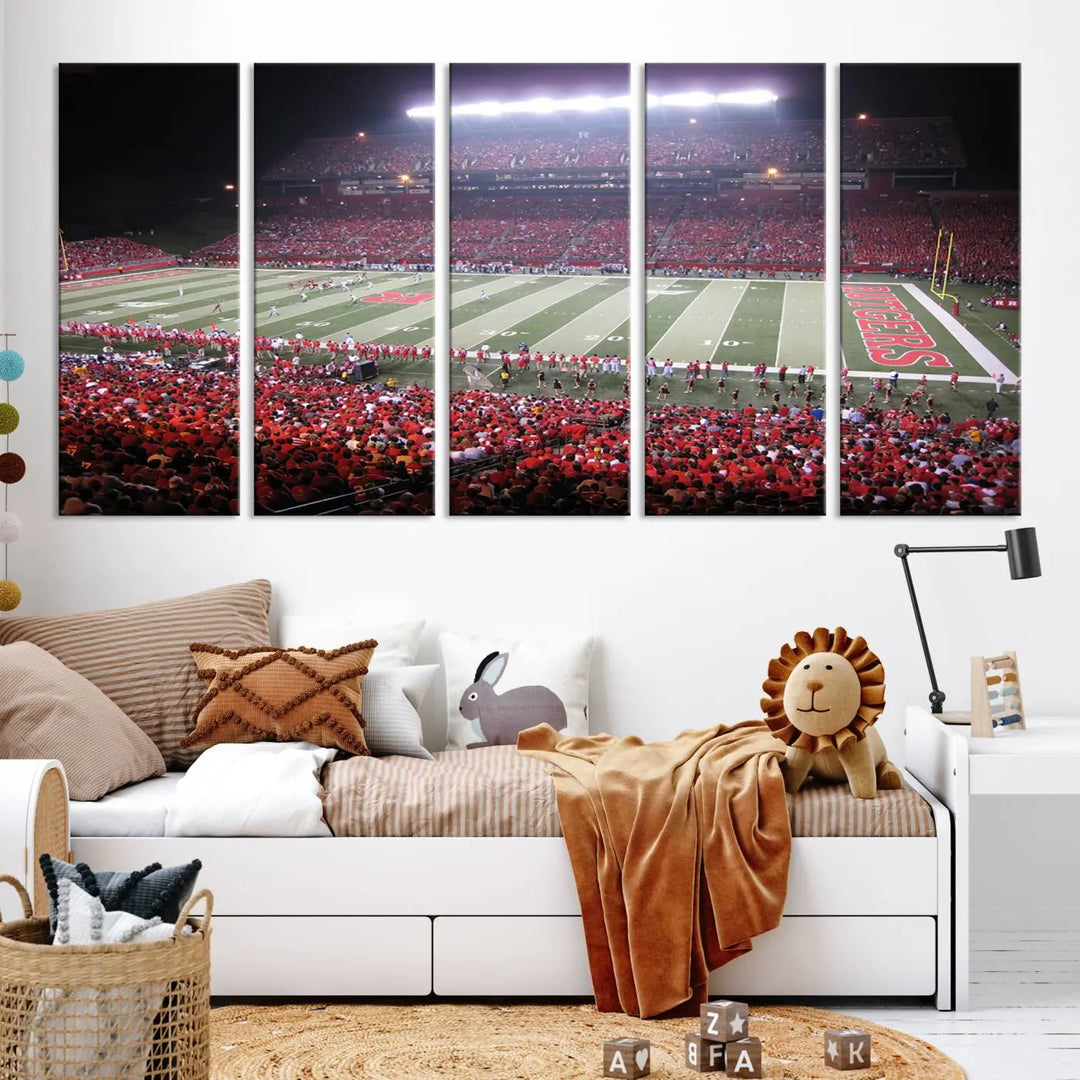 The Rutgers University Scarlet Knights Football Team Print - Piscataway SHI Stadium Wall Art Canvas Print adds an elegant touch to a stylish room. Handmade in the USA, it captures the spirited ambiance of a packed football stadium at night perfectly.