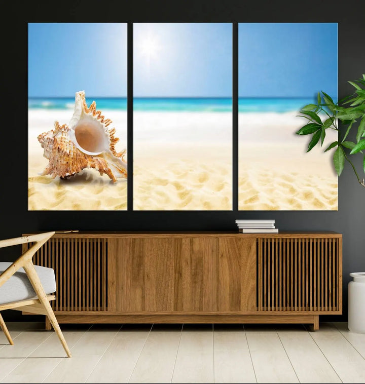 The Sea Shell on The Beach Sun Sand Wall Art Canvas Print is a triptych that beautifully captures a beach scene with a large seashell on the sand.