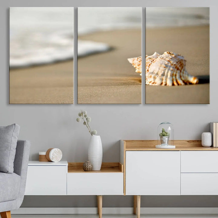 The triptych artwork titled "Sea Shell on the Beach Canvas Wall Art Beach Canvas Print" showcases a seashell on a sandy beach with ocean waves in the background, creating a stunning piece of coastal wall decor.