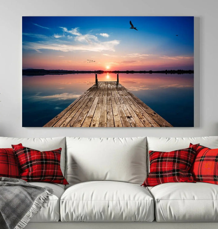 A Sea Wooden Pier Canvas Wall Art, featuring a sunset artwork print of the beach, fosters a coastal ambiance in the modern living room.