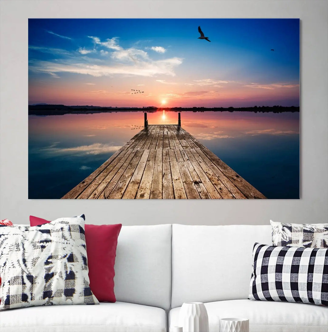 A Sea Wooden Pier Canvas Wall Art, featuring a sunset artwork print of the beach, fosters a coastal ambiance in the modern living room.