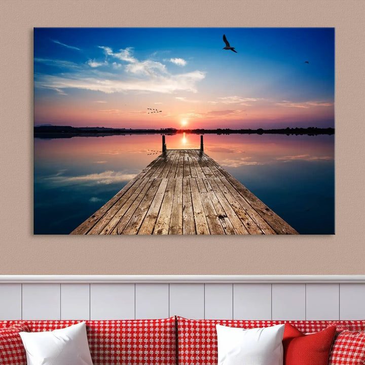 A Sea Wooden Pier Canvas Wall Art, featuring a sunset artwork print of the beach, fosters a coastal ambiance in the modern living room.