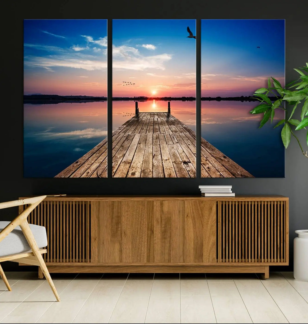 A Sea Wooden Pier Canvas Wall Art, featuring a sunset artwork print of the beach, fosters a coastal ambiance in the modern living room.