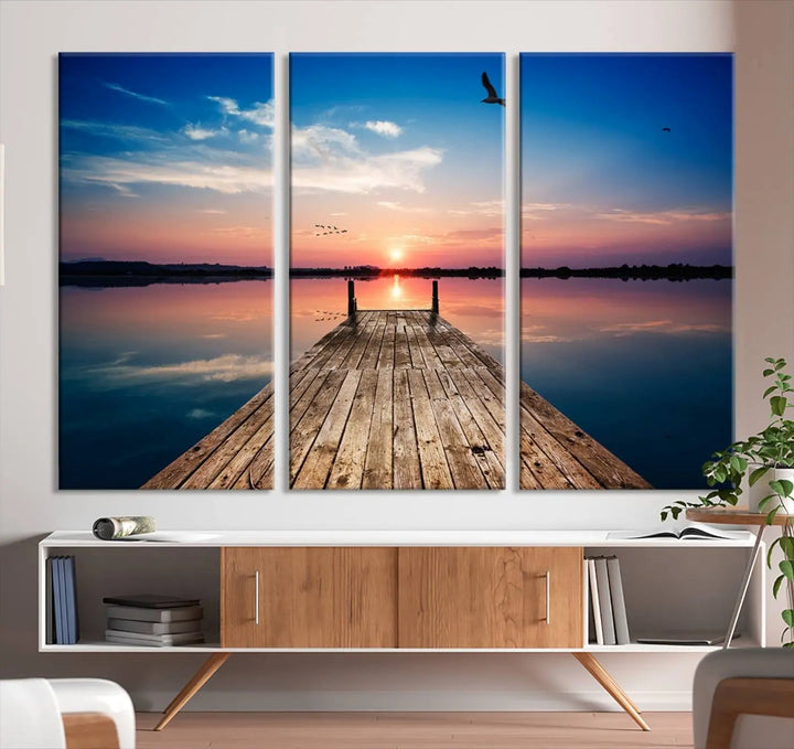 A Sea Wooden Pier Canvas Wall Art, featuring a sunset artwork print of the beach, fosters a coastal ambiance in the modern living room.