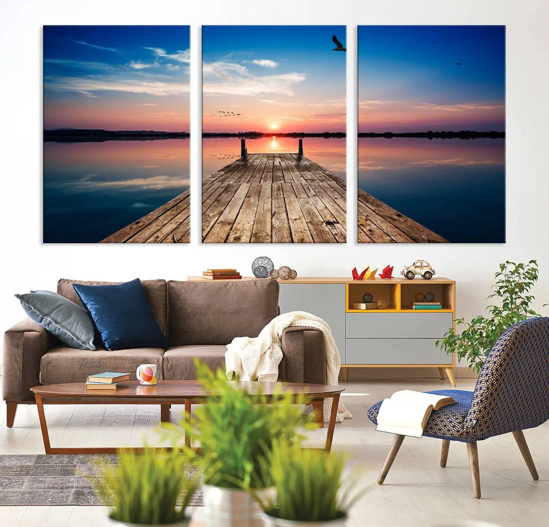 A Sea Wooden Pier Canvas Wall Art, featuring a sunset artwork print of the beach, fosters a coastal ambiance in the modern living room.