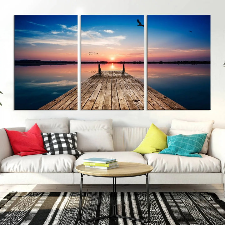 A Sea Wooden Pier Canvas Wall Art, featuring a sunset artwork print of the beach, fosters a coastal ambiance in the modern living room.