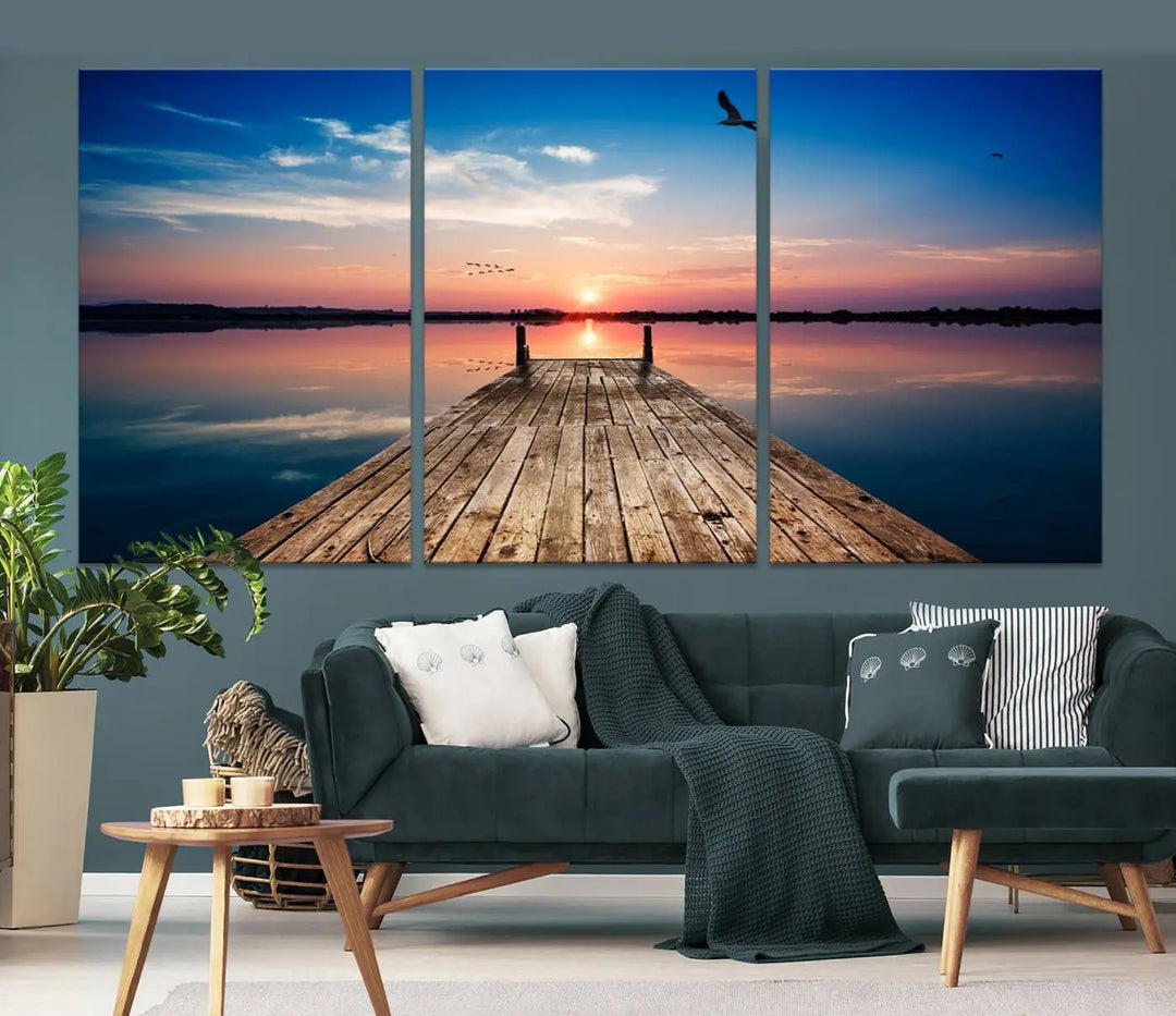 A Sea Wooden Pier Canvas Wall Art, featuring a sunset artwork print of the beach, fosters a coastal ambiance in the modern living room.