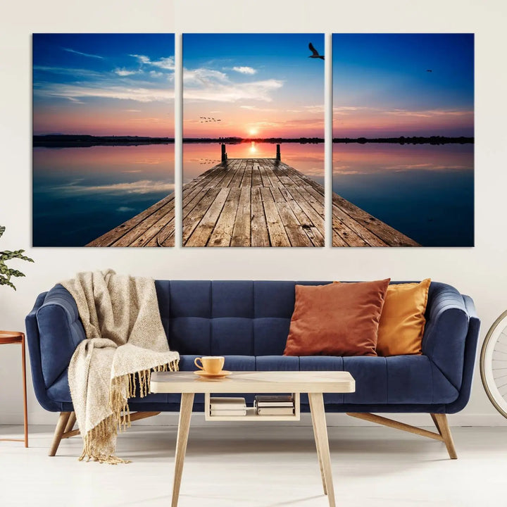 A Sea Wooden Pier Canvas Wall Art, featuring a sunset artwork print of the beach, fosters a coastal ambiance in the modern living room.