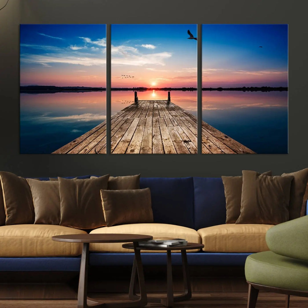 A Sea Wooden Pier Canvas Wall Art, featuring a sunset artwork print of the beach, fosters a coastal ambiance in the modern living room.