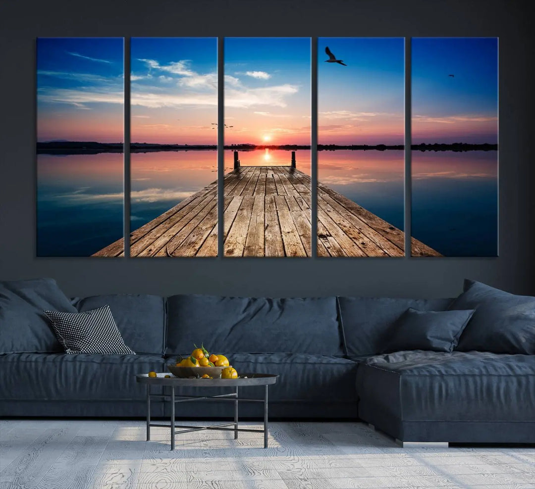 A Sea Wooden Pier Canvas Wall Art, featuring a sunset artwork print of the beach, fosters a coastal ambiance in the modern living room.