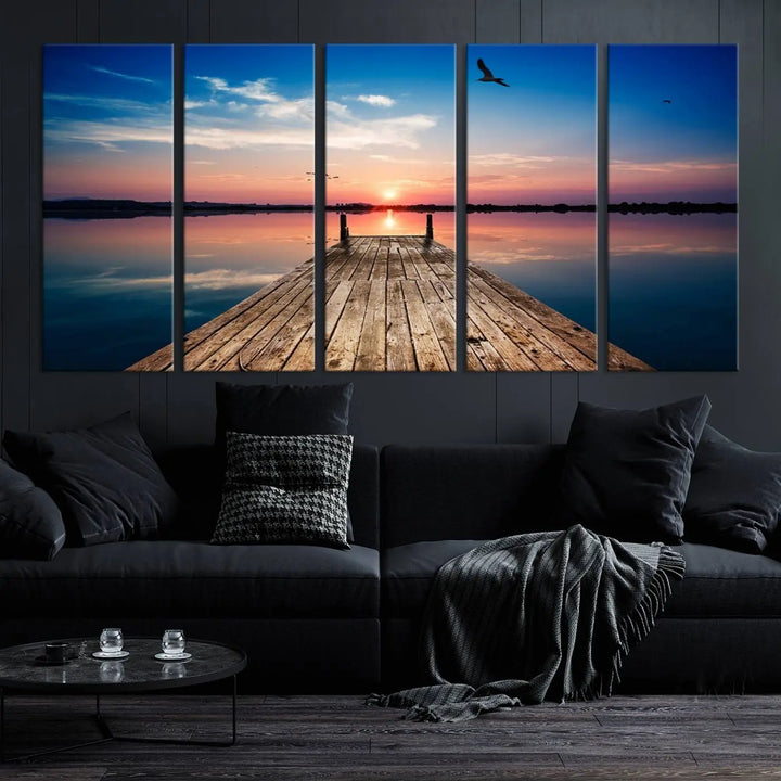 A Sea Wooden Pier Canvas Wall Art, featuring a sunset artwork print of the beach, fosters a coastal ambiance in the modern living room.