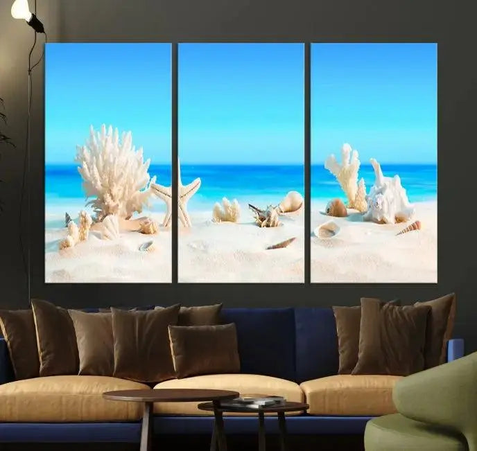 The Seashell Wall Art Canvas Print features a triptych of a beach scene, complete with coral, starfish, and seashells on sand. Printed on museum-quality canvas with UV-protective coating, it is ready to hang and brings vibrant charm to any living room.