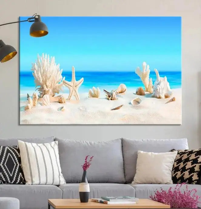 The Seashell Wall Art Canvas Print features a triptych of a beach scene, complete with coral, starfish, and seashells on sand. Printed on museum-quality canvas with UV-protective coating, it is ready to hang and brings vibrant charm to any living room.