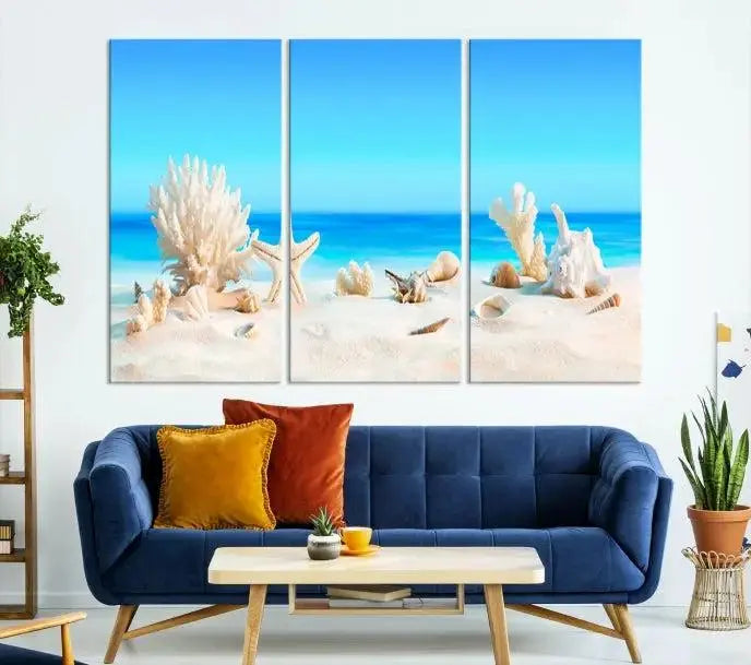 The Seashell Wall Art Canvas Print features a triptych of a beach scene, complete with coral, starfish, and seashells on sand. Printed on museum-quality canvas with UV-protective coating, it is ready to hang and brings vibrant charm to any living room.