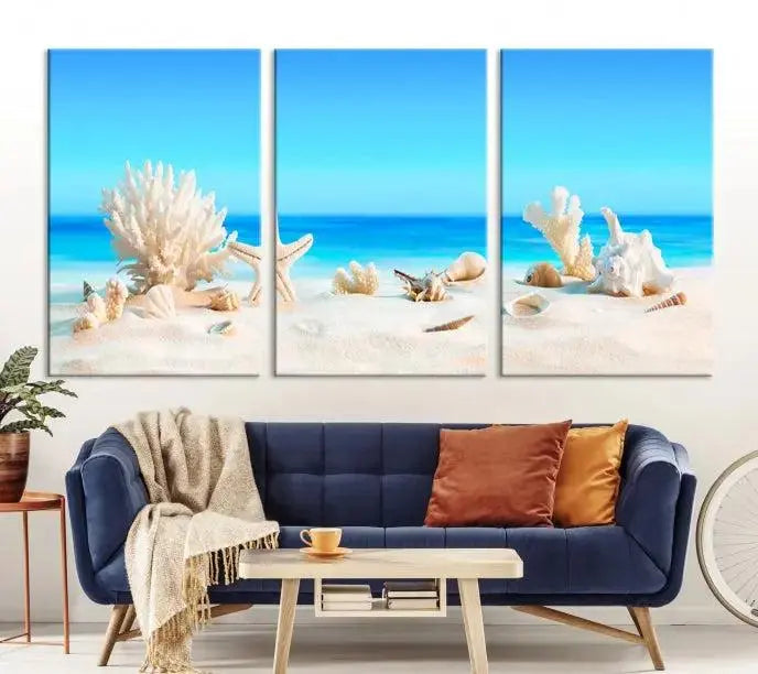 The Seashell Wall Art Canvas Print features a triptych of a beach scene, complete with coral, starfish, and seashells on sand. Printed on museum-quality canvas with UV-protective coating, it is ready to hang and brings vibrant charm to any living room.