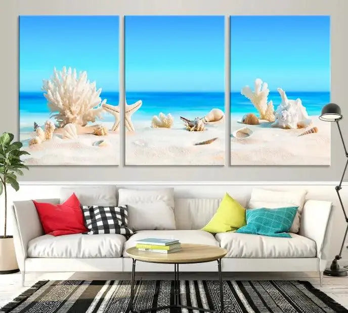 The Seashell Wall Art Canvas Print features a triptych of a beach scene, complete with coral, starfish, and seashells on sand. Printed on museum-quality canvas with UV-protective coating, it is ready to hang and brings vibrant charm to any living room.