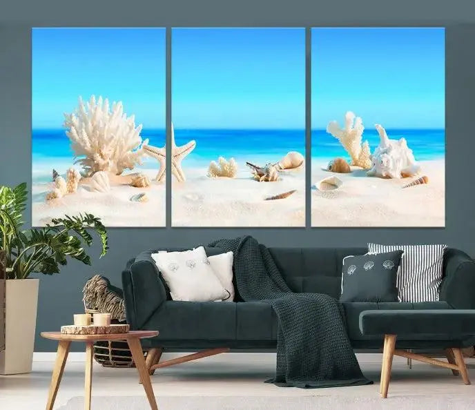 The Seashell Wall Art Canvas Print features a triptych of a beach scene, complete with coral, starfish, and seashells on sand. Printed on museum-quality canvas with UV-protective coating, it is ready to hang and brings vibrant charm to any living room.