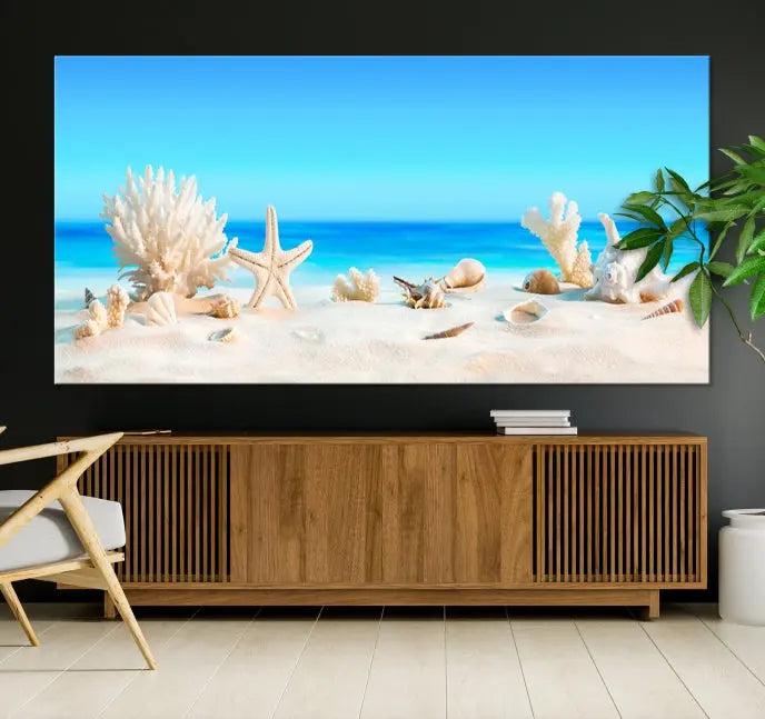 The Seashell Wall Art Canvas Print features a triptych of a beach scene, complete with coral, starfish, and seashells on sand. Printed on museum-quality canvas with UV-protective coating, it is ready to hang and brings vibrant charm to any living room.