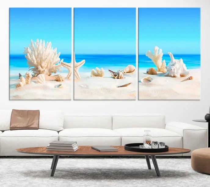 The Seashell Wall Art Canvas Print features a triptych of a beach scene, complete with coral, starfish, and seashells on sand. Printed on museum-quality canvas with UV-protective coating, it is ready to hang and brings vibrant charm to any living room.