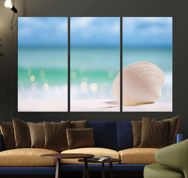 The "Seashell on The Beach Wall Art Canvas Print" features a triptych photo of a seashell on a sandy beach. This artwork is printed on gallery-wrapped, museum-quality canvas with a UV-protective coating.