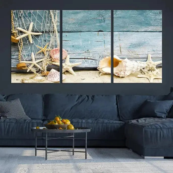 The beautiful three-panel canvas print, "Seashells on Rustic Wooden Background," features seashells and starfish against a blue wood background. The gallery-wrapped panels are coated with UV protection to ensure long-lasting vibrancy.