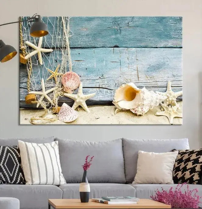 The beautiful three-panel canvas print, "Seashells on Rustic Wooden Background," features seashells and starfish against a blue wood background. The gallery-wrapped panels are coated with UV protection to ensure long-lasting vibrancy.