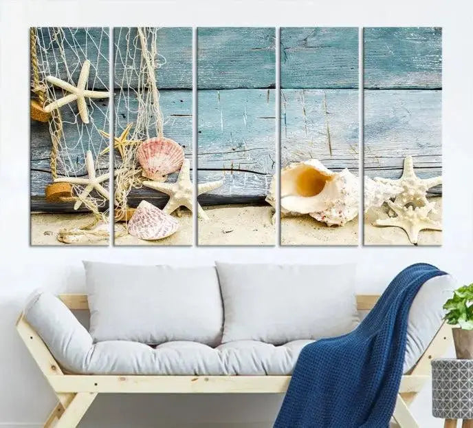 The beautiful three-panel canvas print, "Seashells on Rustic Wooden Background," features seashells and starfish against a blue wood background. The gallery-wrapped panels are coated with UV protection to ensure long-lasting vibrancy.