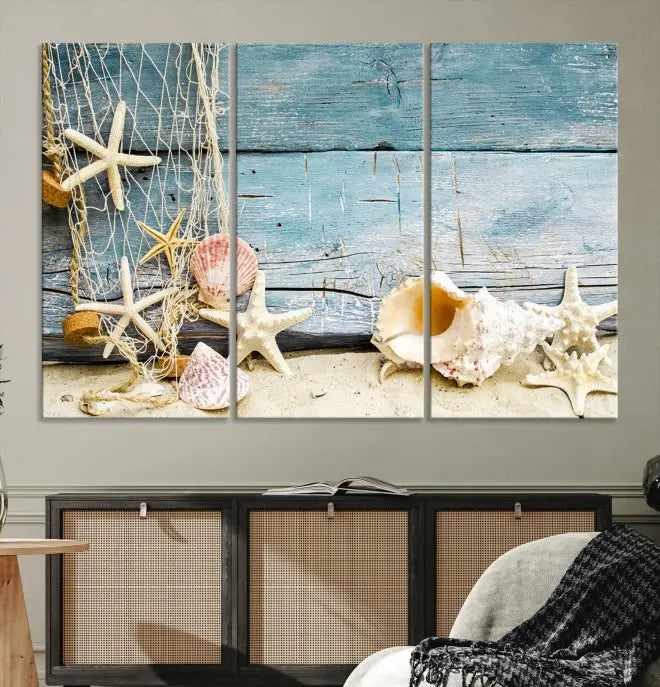 The beautiful three-panel canvas print, "Seashells on Rustic Wooden Background," features seashells and starfish against a blue wood background. The gallery-wrapped panels are coated with UV protection to ensure long-lasting vibrancy.