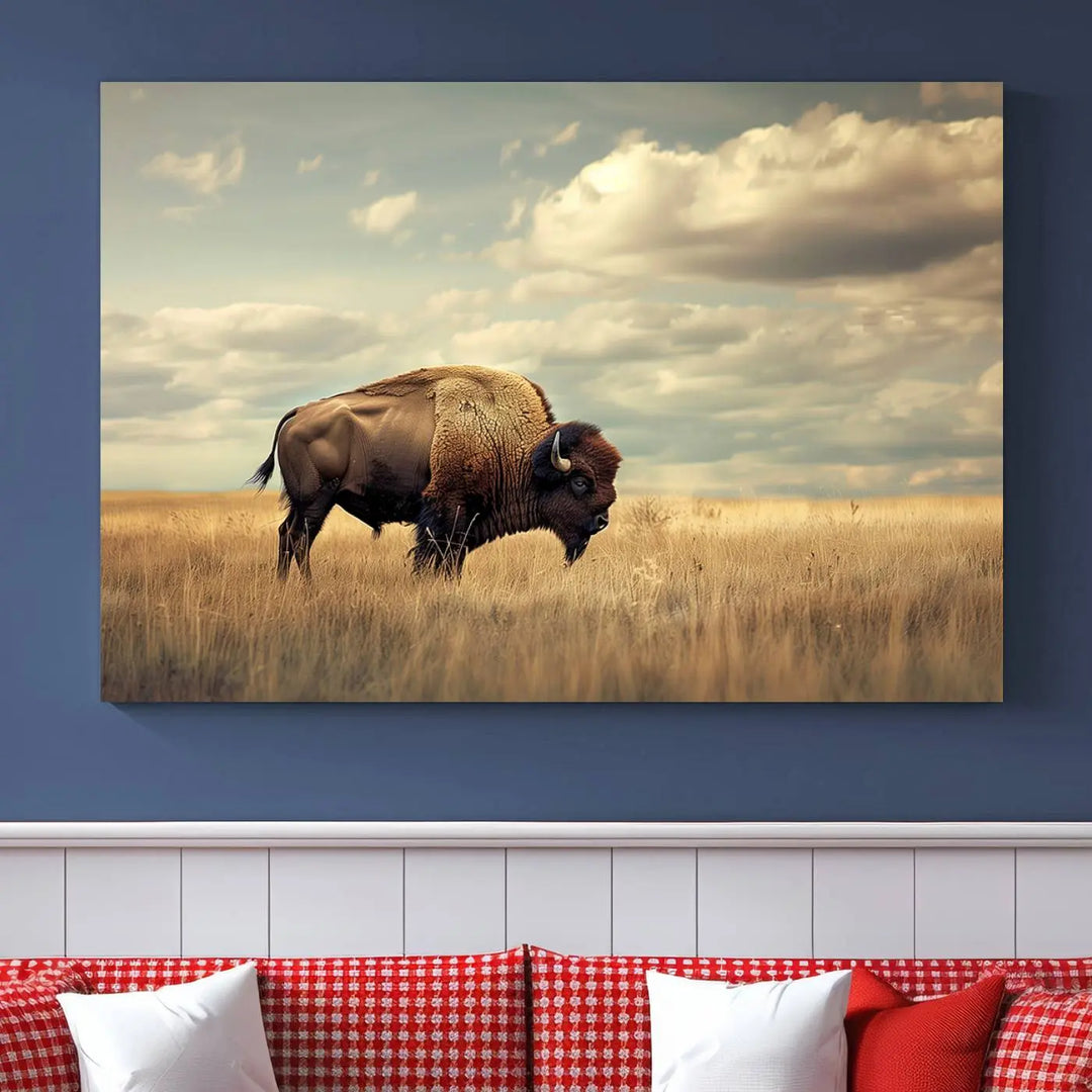 The Sepia American Bison Wall Art Print, a Western canvas print, depicts a bison standing in a grassy field beneath a cloudy sky. This high-resolution museum-quality triptych wall art is ideal for farmhouse wall decor.