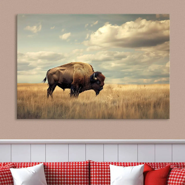 The Sepia American Bison Wall Art Print, a Western canvas print, depicts a bison standing in a grassy field beneath a cloudy sky. This high-resolution museum-quality triptych wall art is ideal for farmhouse wall decor.