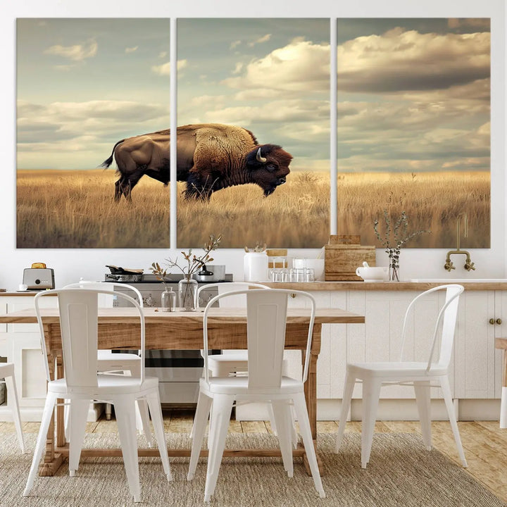 The Sepia American Bison Wall Art Print, a Western canvas print, depicts a bison standing in a grassy field beneath a cloudy sky. This high-resolution museum-quality triptych wall art is ideal for farmhouse wall decor.