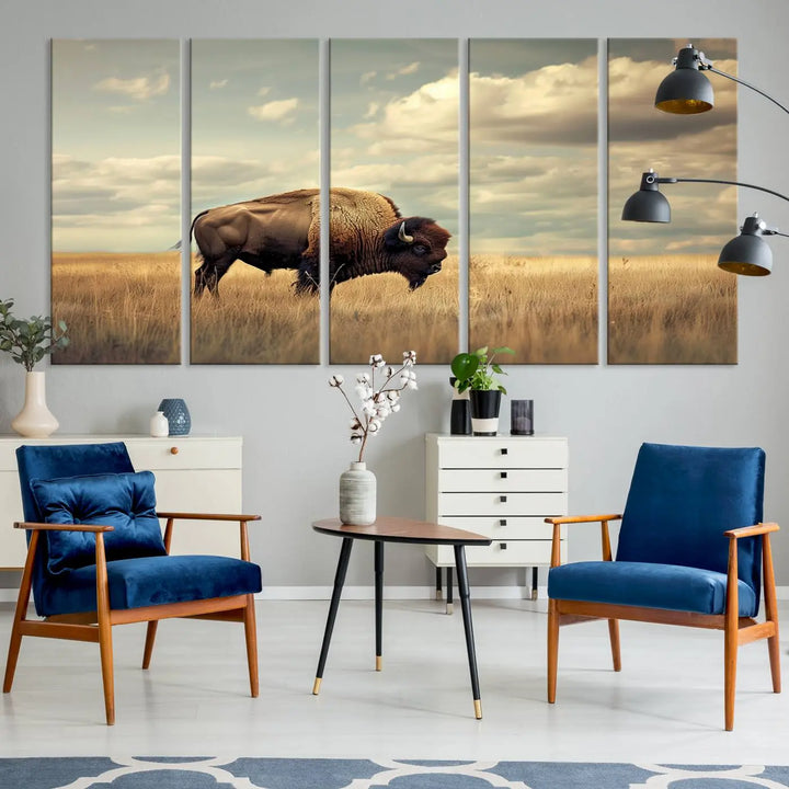 The Sepia American Bison Wall Art Print, a Western canvas print, depicts a bison standing in a grassy field beneath a cloudy sky. This high-resolution museum-quality triptych wall art is ideal for farmhouse wall decor.