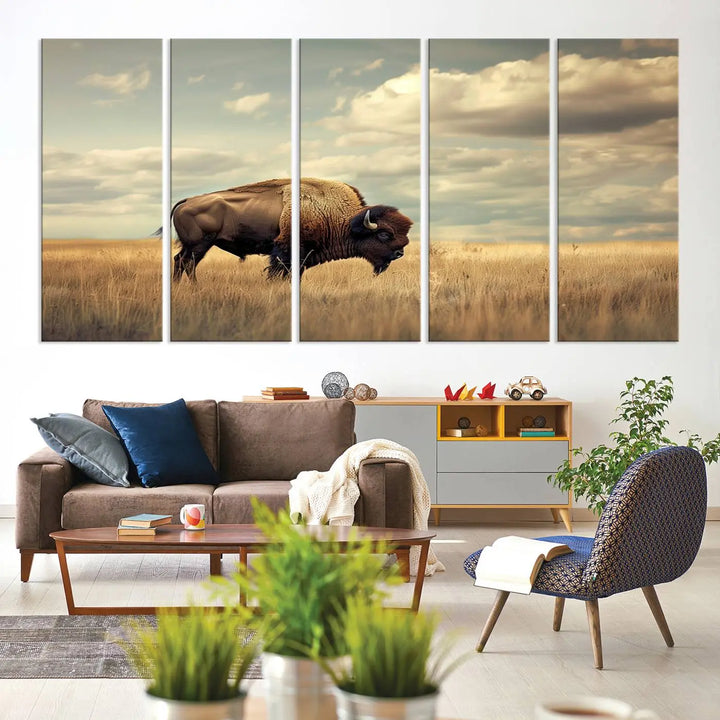 The Sepia American Bison Wall Art Print, a Western canvas print, depicts a bison standing in a grassy field beneath a cloudy sky. This high-resolution museum-quality triptych wall art is ideal for farmhouse wall decor.