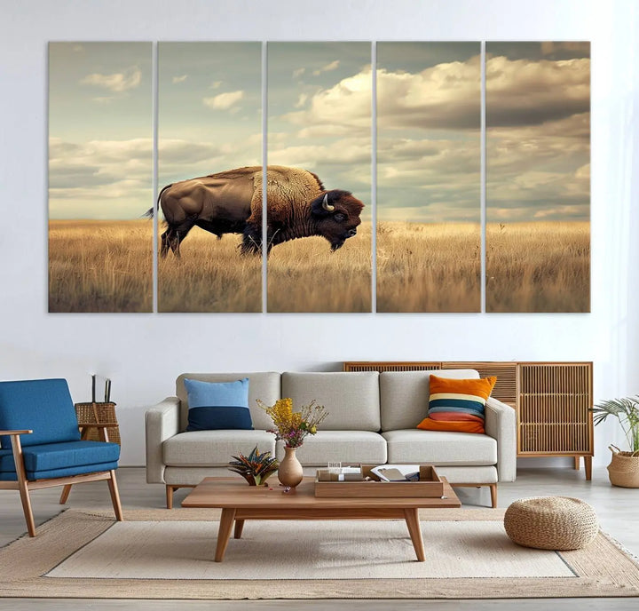 The Sepia American Bison Wall Art Print, a Western canvas print, depicts a bison standing in a grassy field beneath a cloudy sky. This high-resolution museum-quality triptych wall art is ideal for farmhouse wall decor.