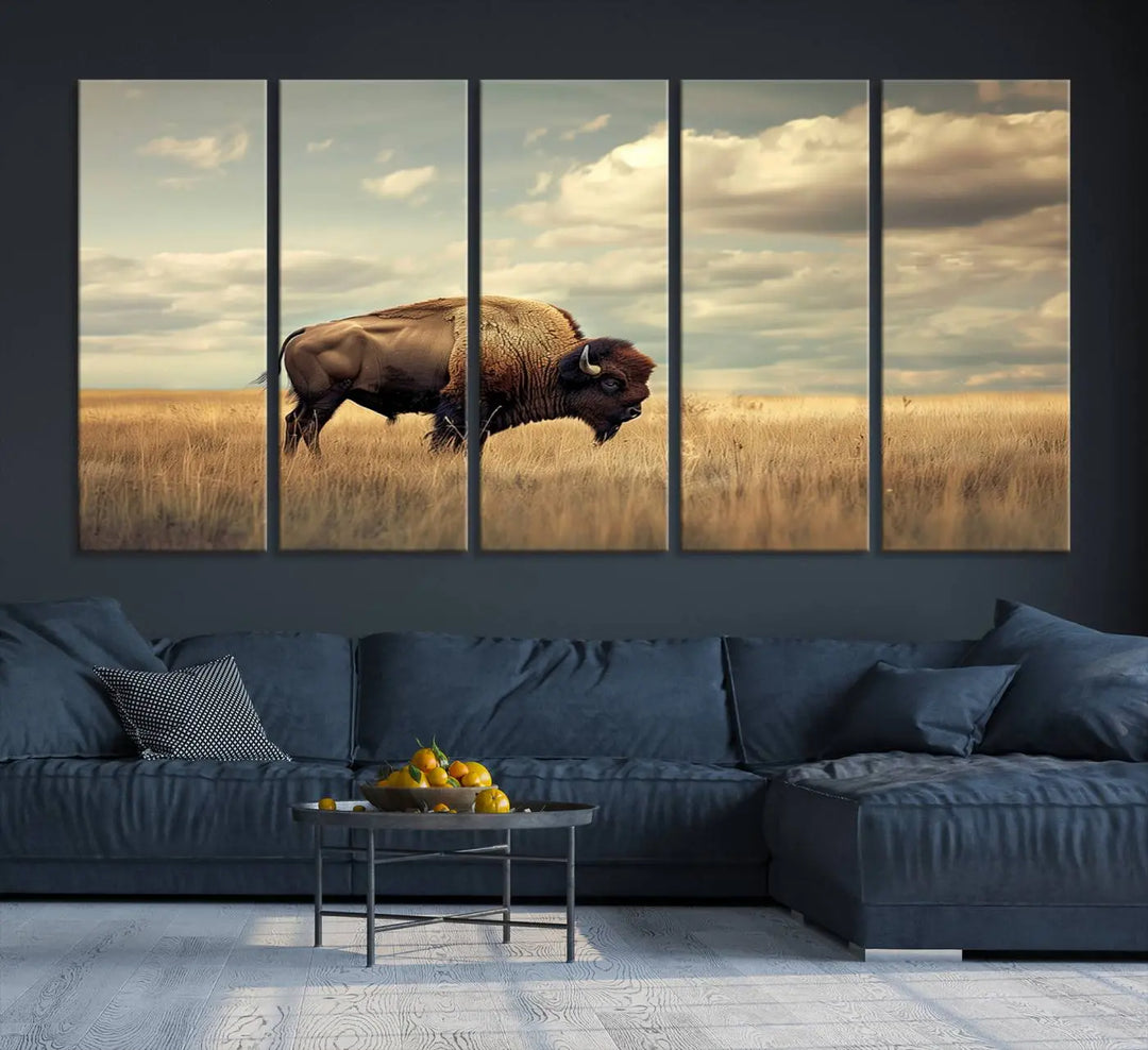 The Sepia American Bison Wall Art Print, a Western canvas print, depicts a bison standing in a grassy field beneath a cloudy sky. This high-resolution museum-quality triptych wall art is ideal for farmhouse wall decor.