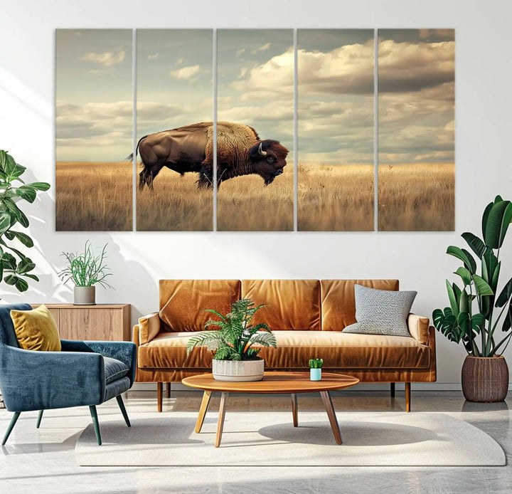 The Sepia American Bison Wall Art Print, a Western canvas print, depicts a bison standing in a grassy field beneath a cloudy sky. This high-resolution museum-quality triptych wall art is ideal for farmhouse wall decor.