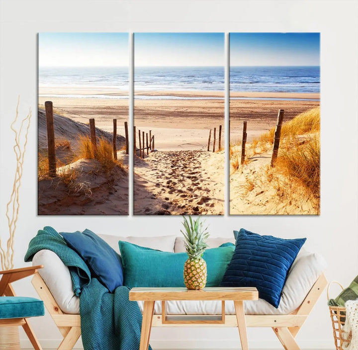 A triptych of Serene Beach Path Canvas Art, a giclee canvas print with gallery wrap, adorns the wall. This stunning coastal sand dunes wall art, crafted with Canon print quality, adds a tranquil touch to the space.