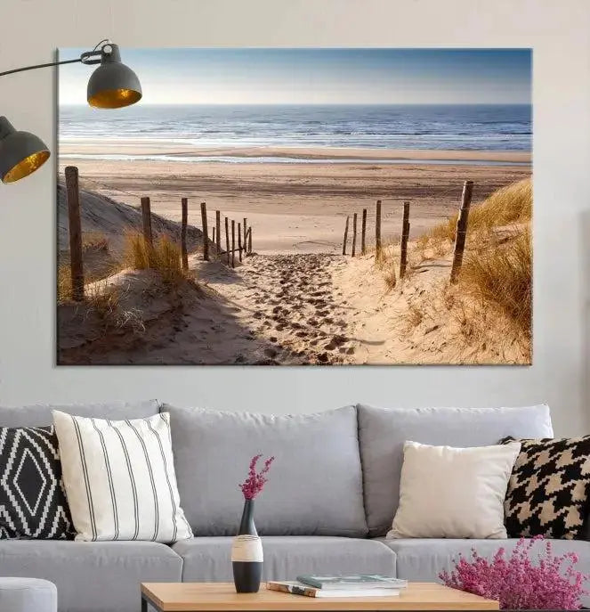 The "Serene Beach Path Canvas – Coastal Landscape Wall Art Triptych – Tranquil Ocean View for Living Room" is tastefully displayed, adding a beautiful coastal touch to the room's ambiance.