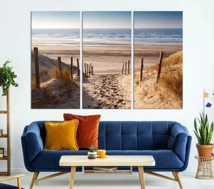 The "Serene Beach Path Canvas – Coastal Landscape Wall Art Triptych – Tranquil Ocean View for Living Room" is tastefully displayed, adding a beautiful coastal touch to the room's ambiance.