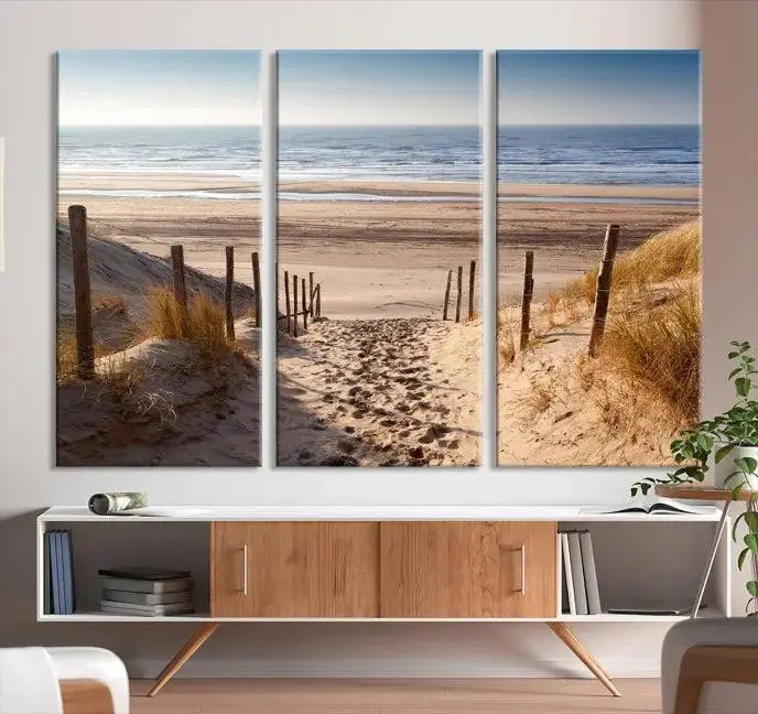 The "Serene Beach Path Canvas – Coastal Landscape Wall Art Triptych – Tranquil Ocean View for Living Room" is tastefully displayed, adding a beautiful coastal touch to the room's ambiance.