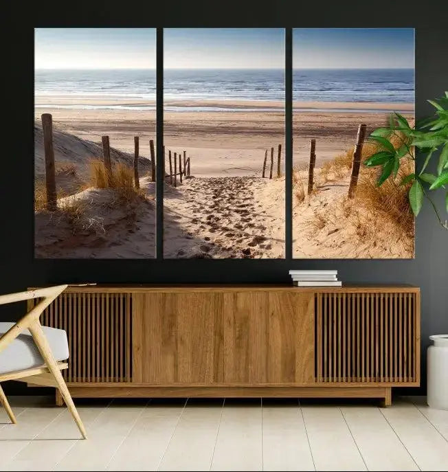 The "Serene Beach Path Canvas – Coastal Landscape Wall Art Triptych – Tranquil Ocean View for Living Room" is tastefully displayed, adding a beautiful coastal touch to the room's ambiance.